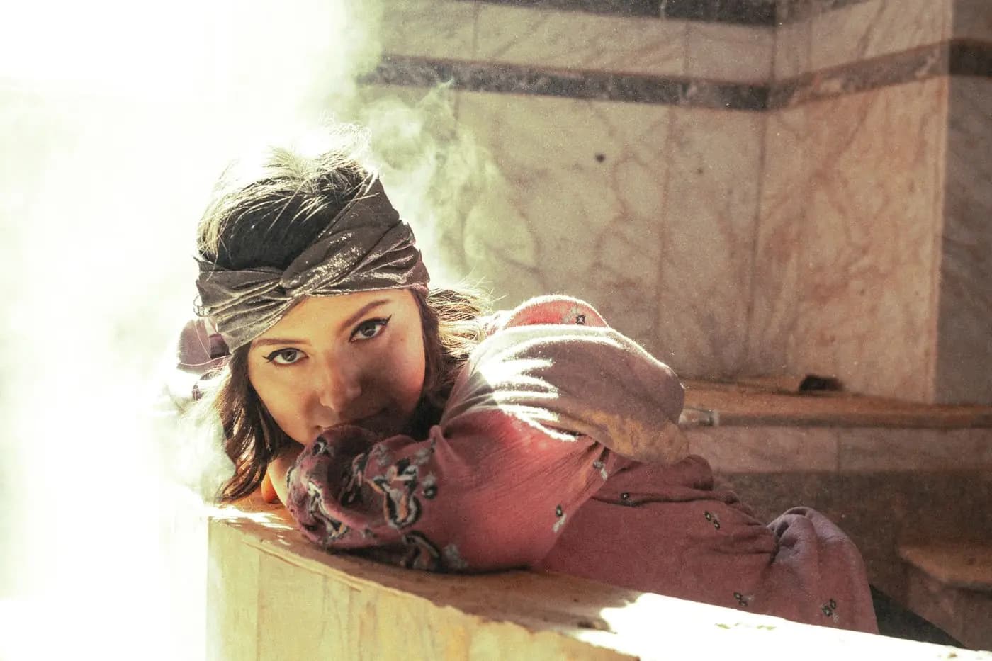 Woman relaxing in a hammam, soft light and steam
