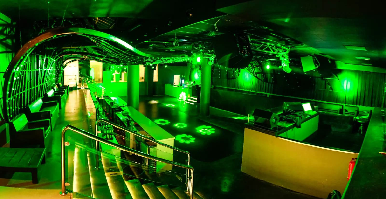 Mya Valencia room bathed in green light with dance floor and balconies
