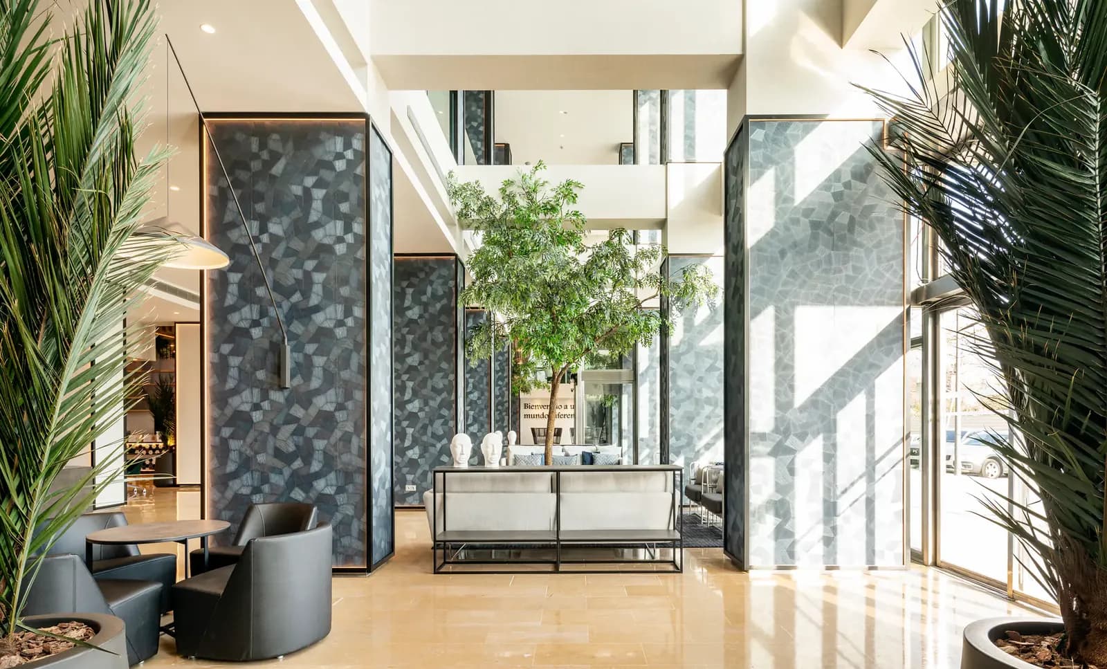 Bright lobby of Ilunion Valencia 4 hotel with plants and armchairs in Valencia