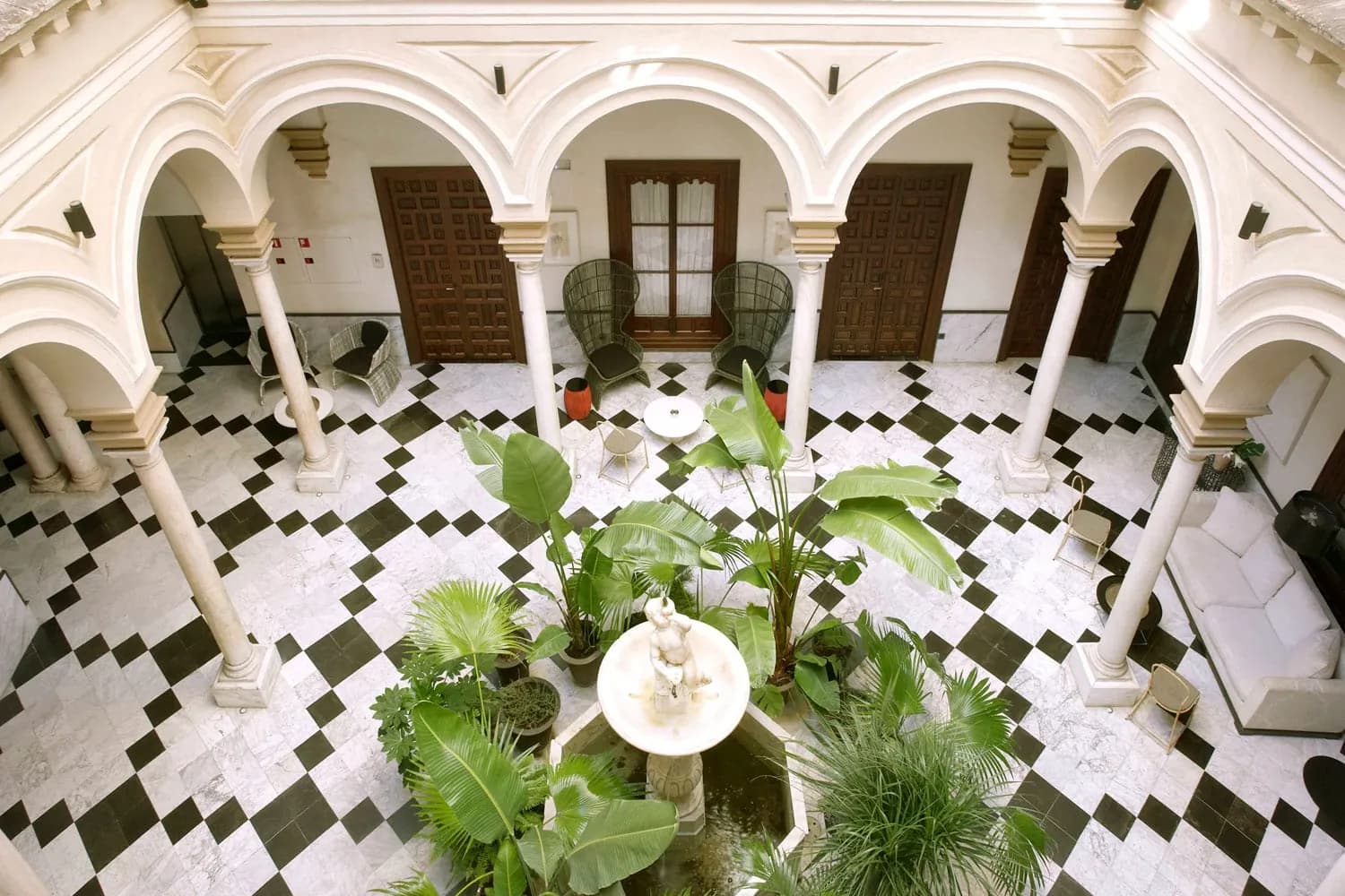 Inner courtyard of Palacio de Villapanés in Seville with checkered floor and plants
