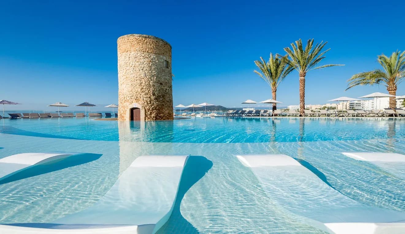 Infinity-Pool des Hotels Torre del Mar mit seinem historischen Turm, mit Blick auf Playa d'en Bossa, Ibiza