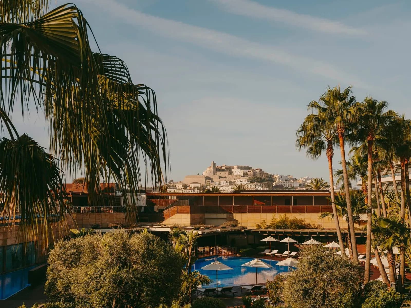 View of the pool and old town of Ibiza from Ibiza Gran Hotel, with palm trees and white buildings