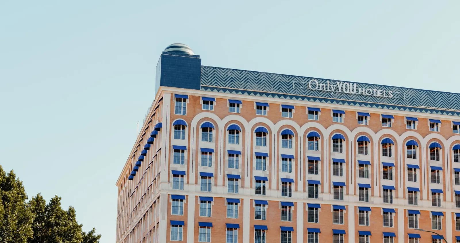 Only YOU Hotel Sevilla 磚砌外牆的建築立面，掛有酒店招牌