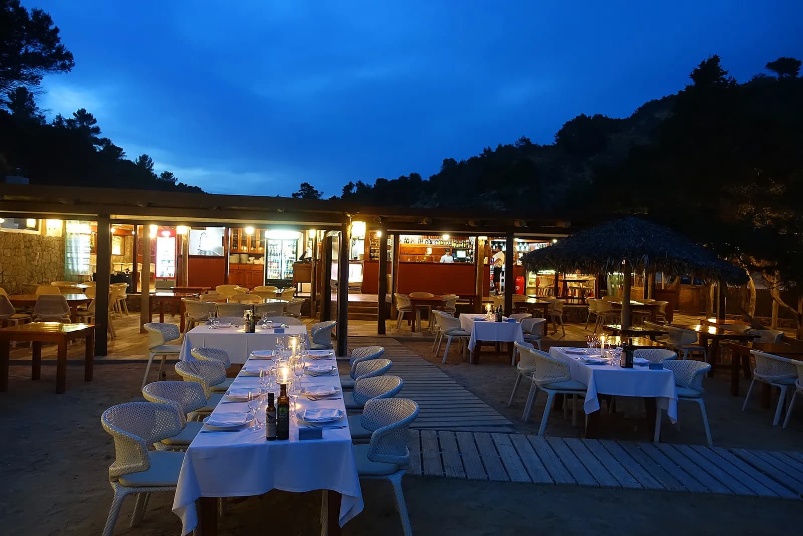 Lit evening terrace of Es Torrent restaurant in Ibiza with set tables