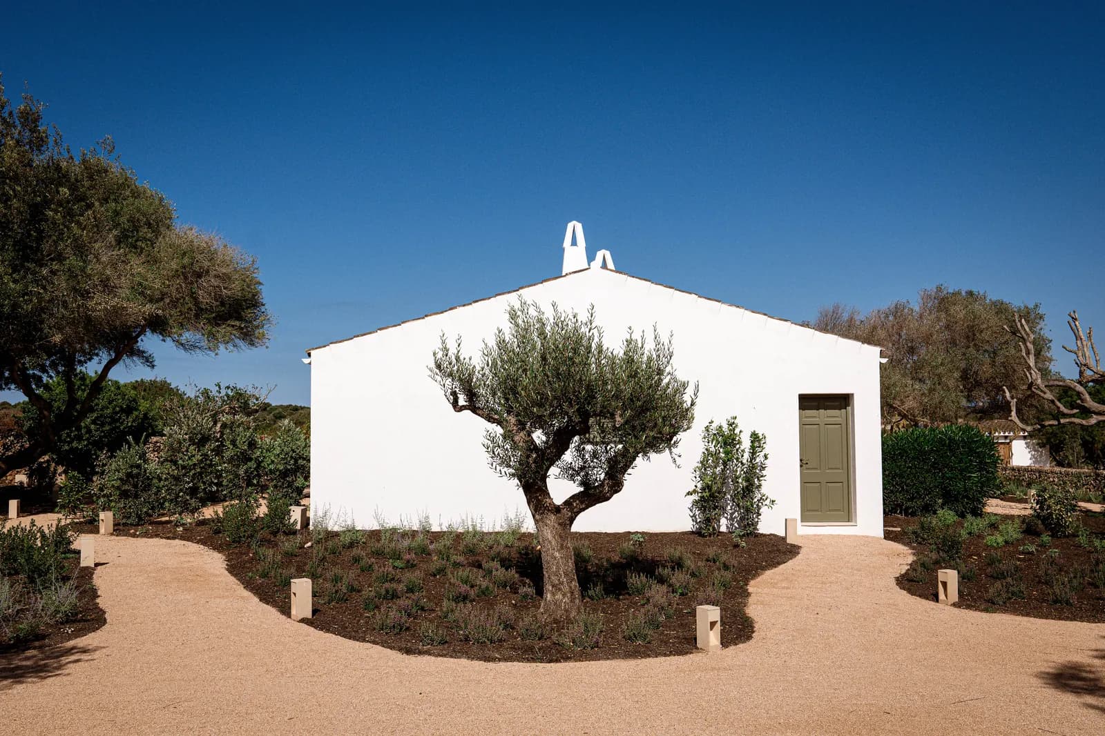 Smoix restaurant white facade surrounded by trees in Ciutadella