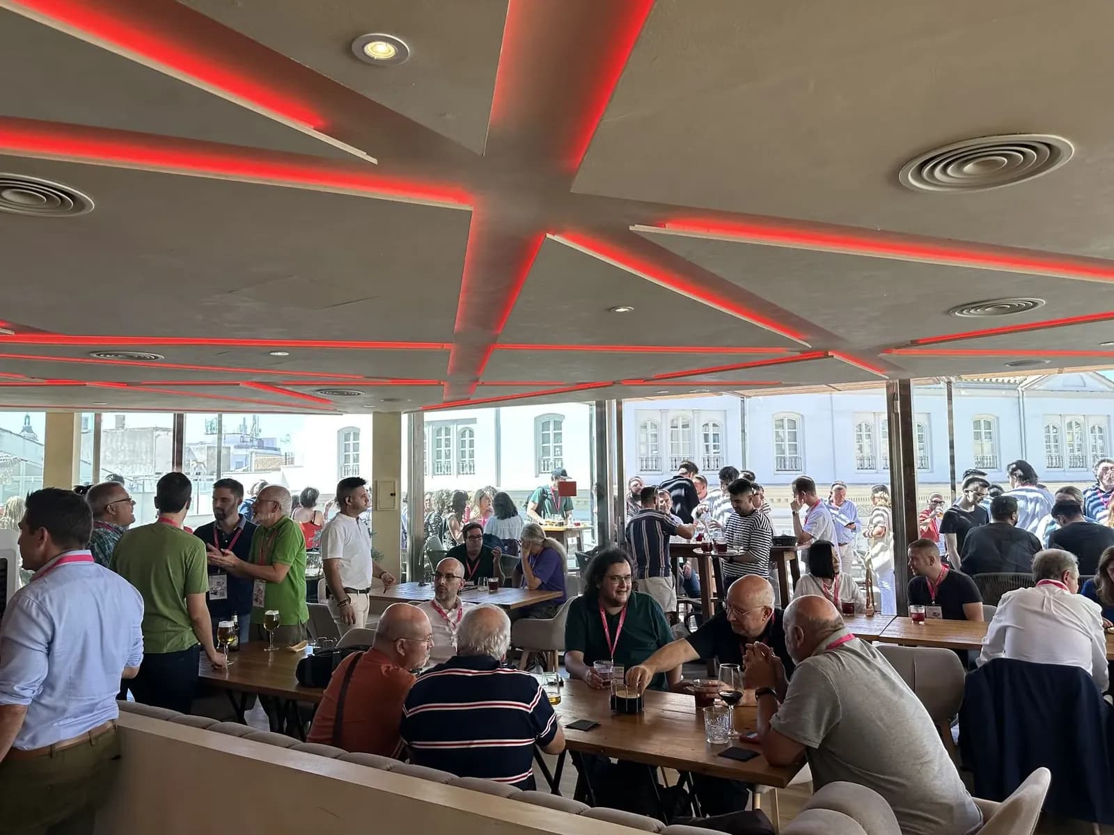 Busy interior of Terraza Catedral in Málaga, red neon ceiling and guests