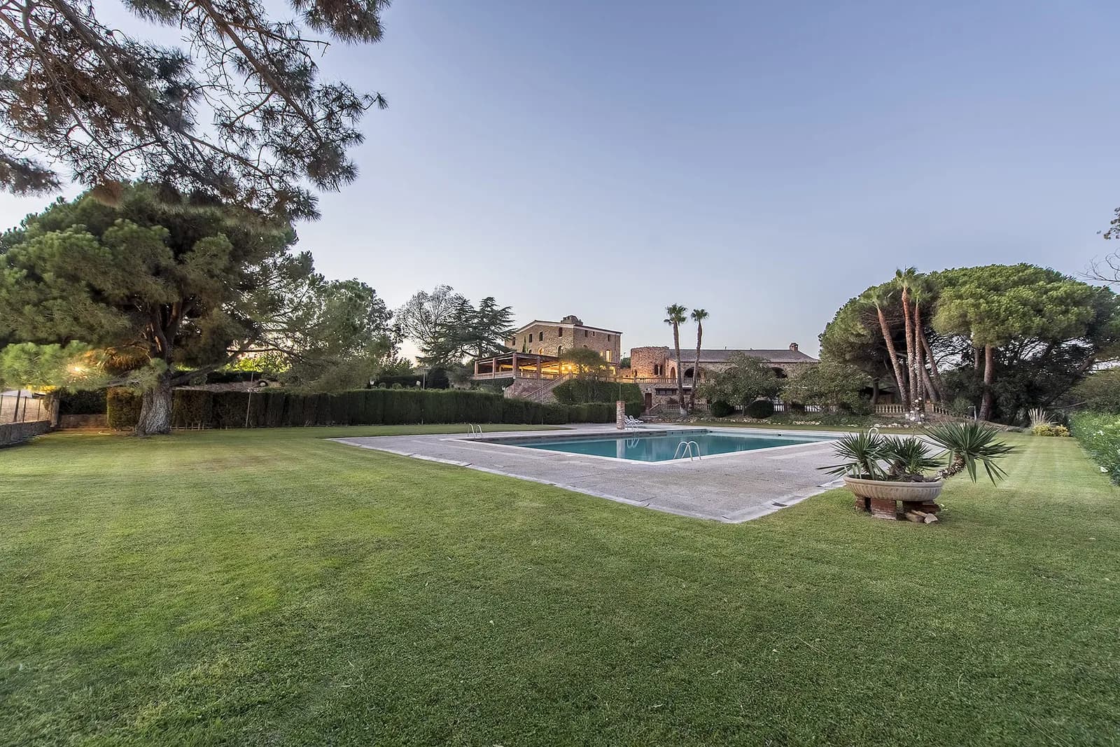 Overview of the Can Tarranc estate, lawn and pool at dusk