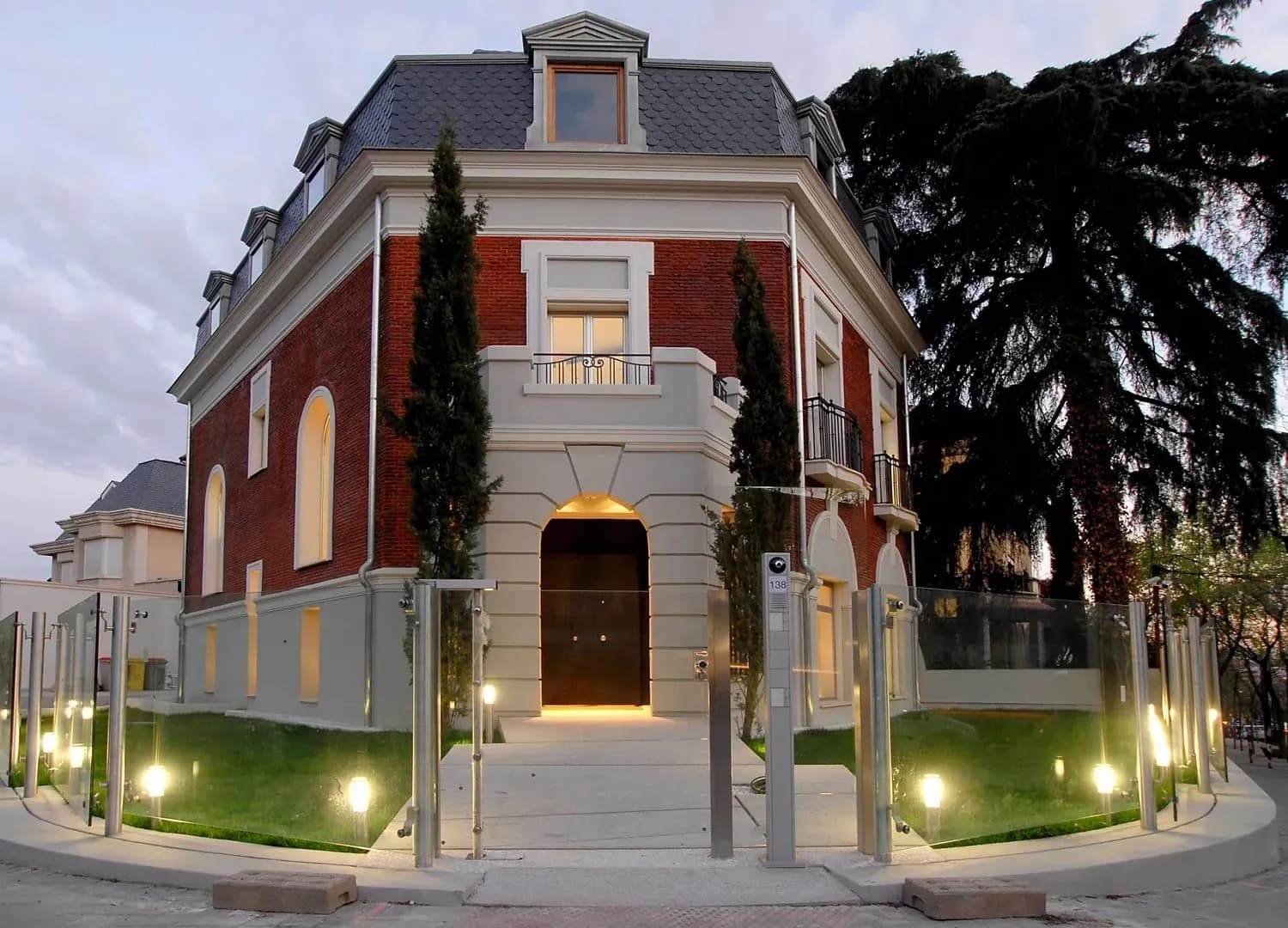 Facade of Fundación Pons in Madrid, brick villa lit in the evening