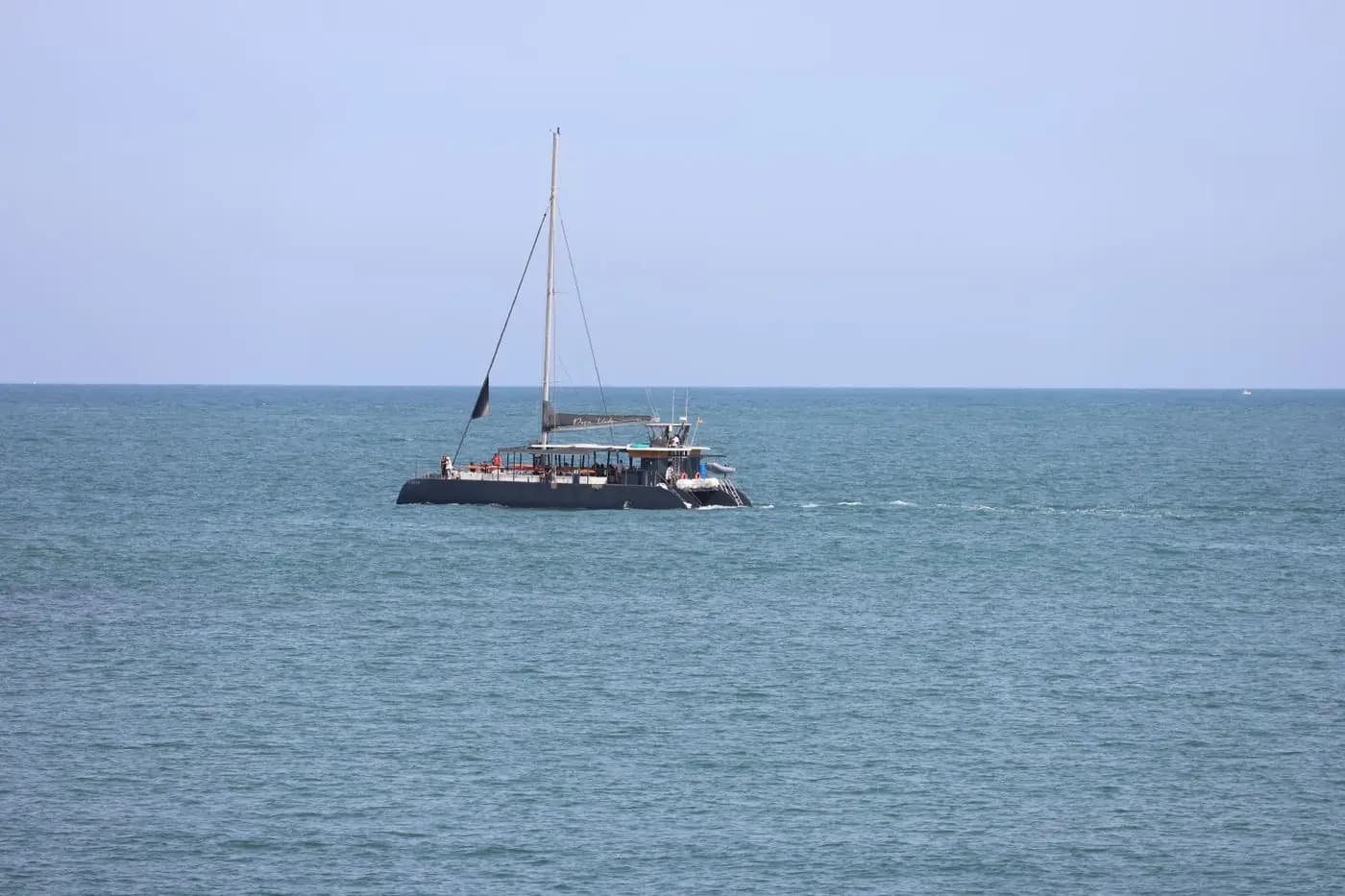 Zeilcatamaran op een kalme zee onder een heldere lucht