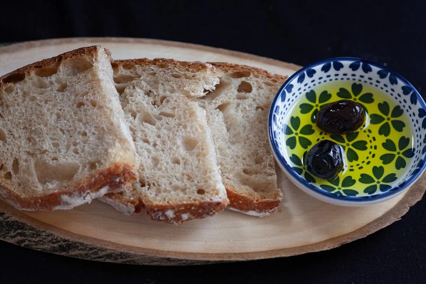 Bauernbrot und eine Schale natives Olivenöl extra mit Oliven
