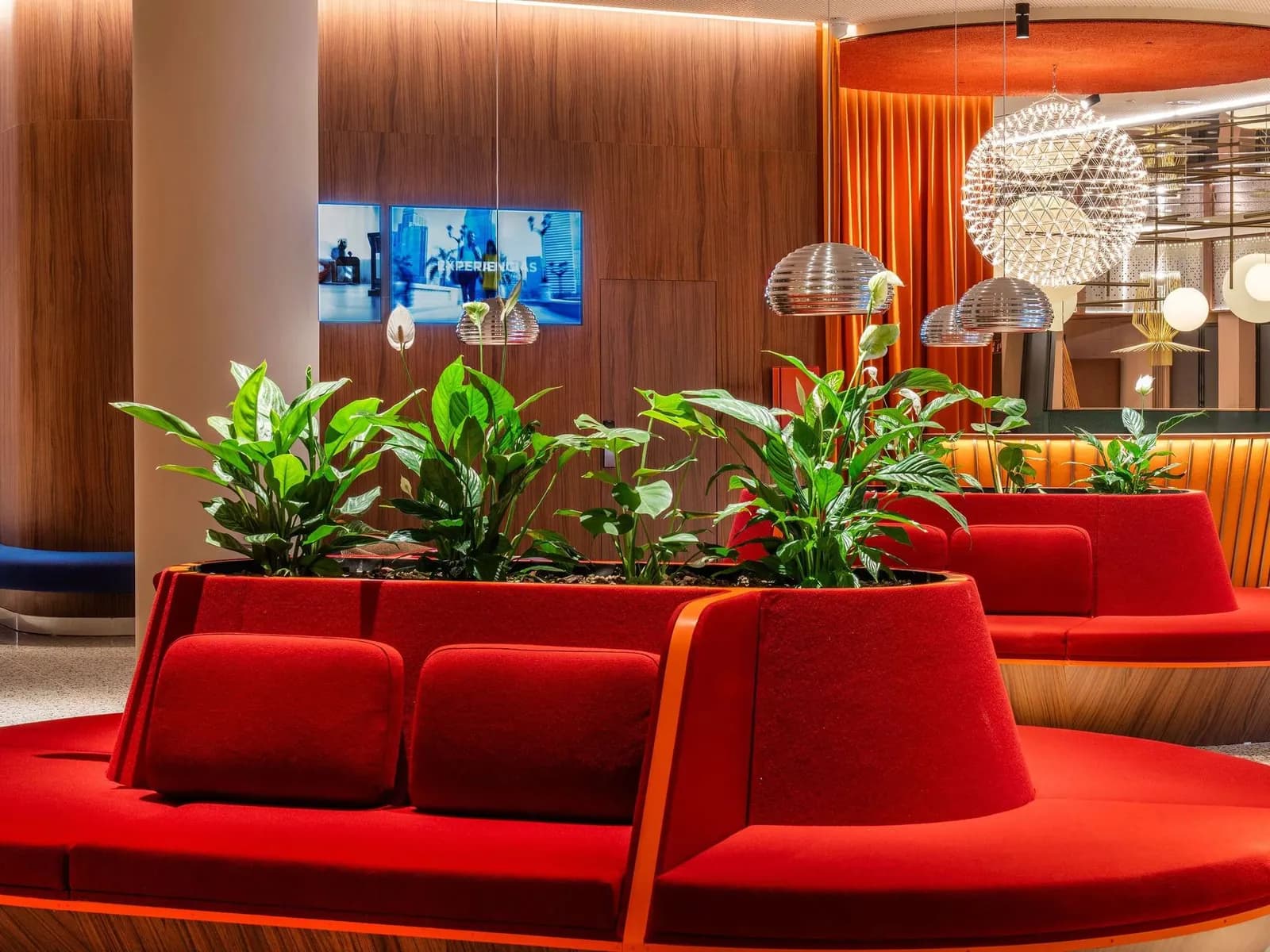 Lounge area with red sofas and plants at Novotel Madrid Campo de las Naciones