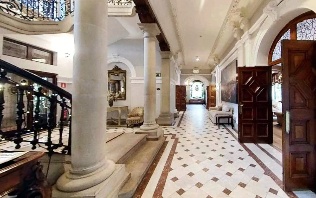 Columned main hall and wrought-iron staircase of Palacio San Joseren in Getxo