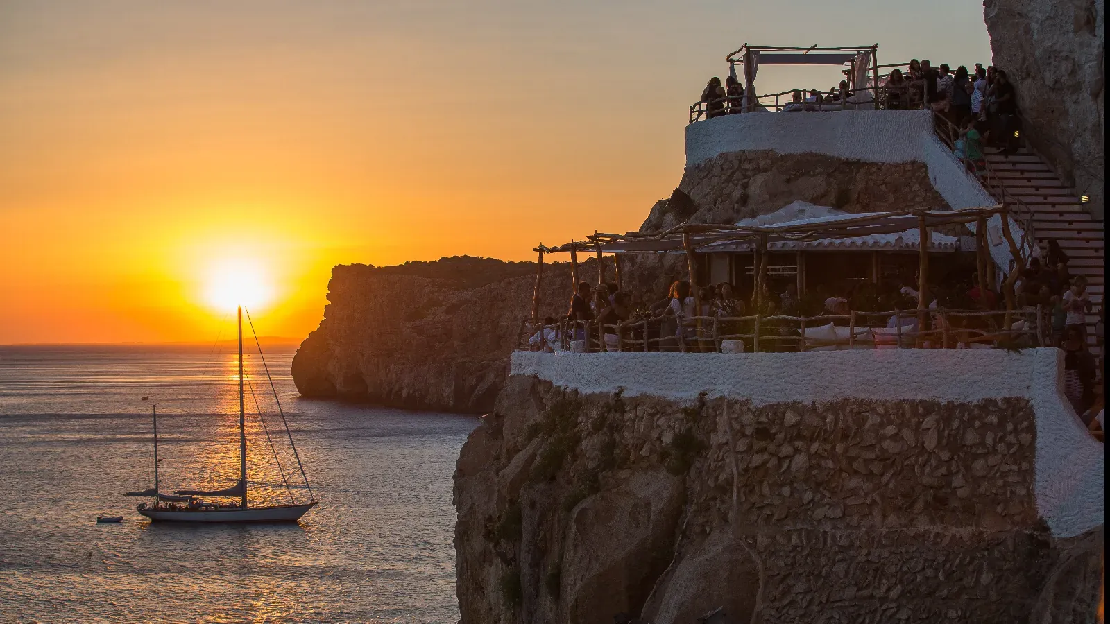 Cova d'en Xoroi terrace at sunset facing the sea in Menorca