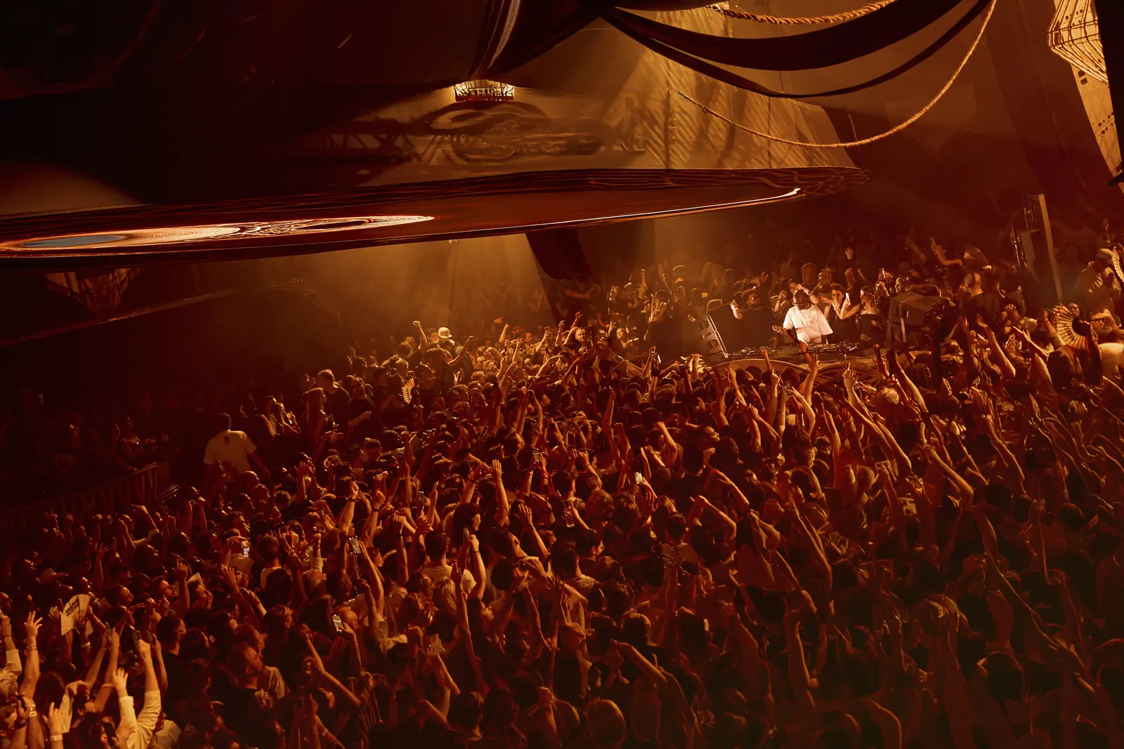 Hï Ibiza crowd in warm orange light during a night event