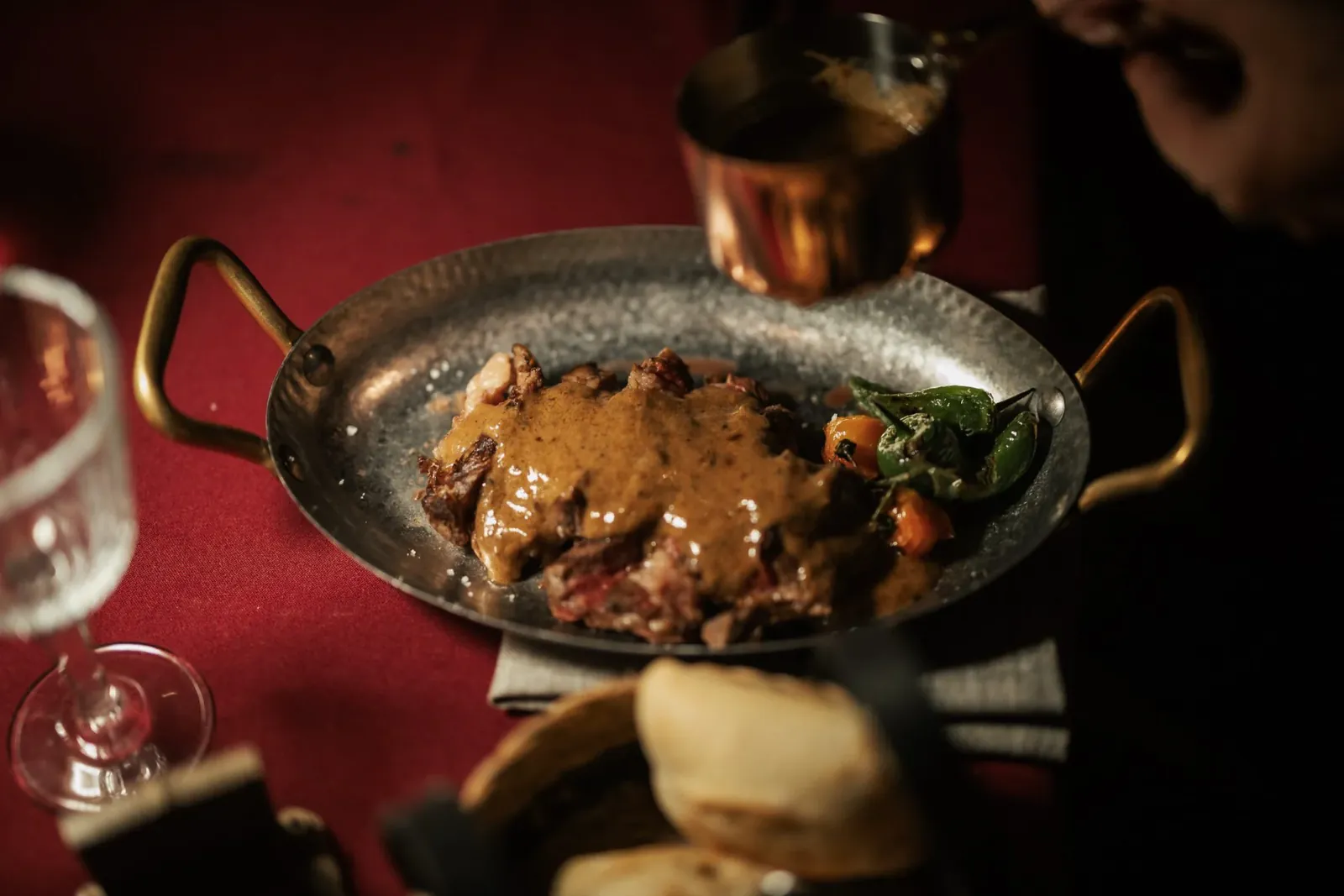 Viande en sauce servie dans une poêle en cuivre au restaurant LØV Marbella