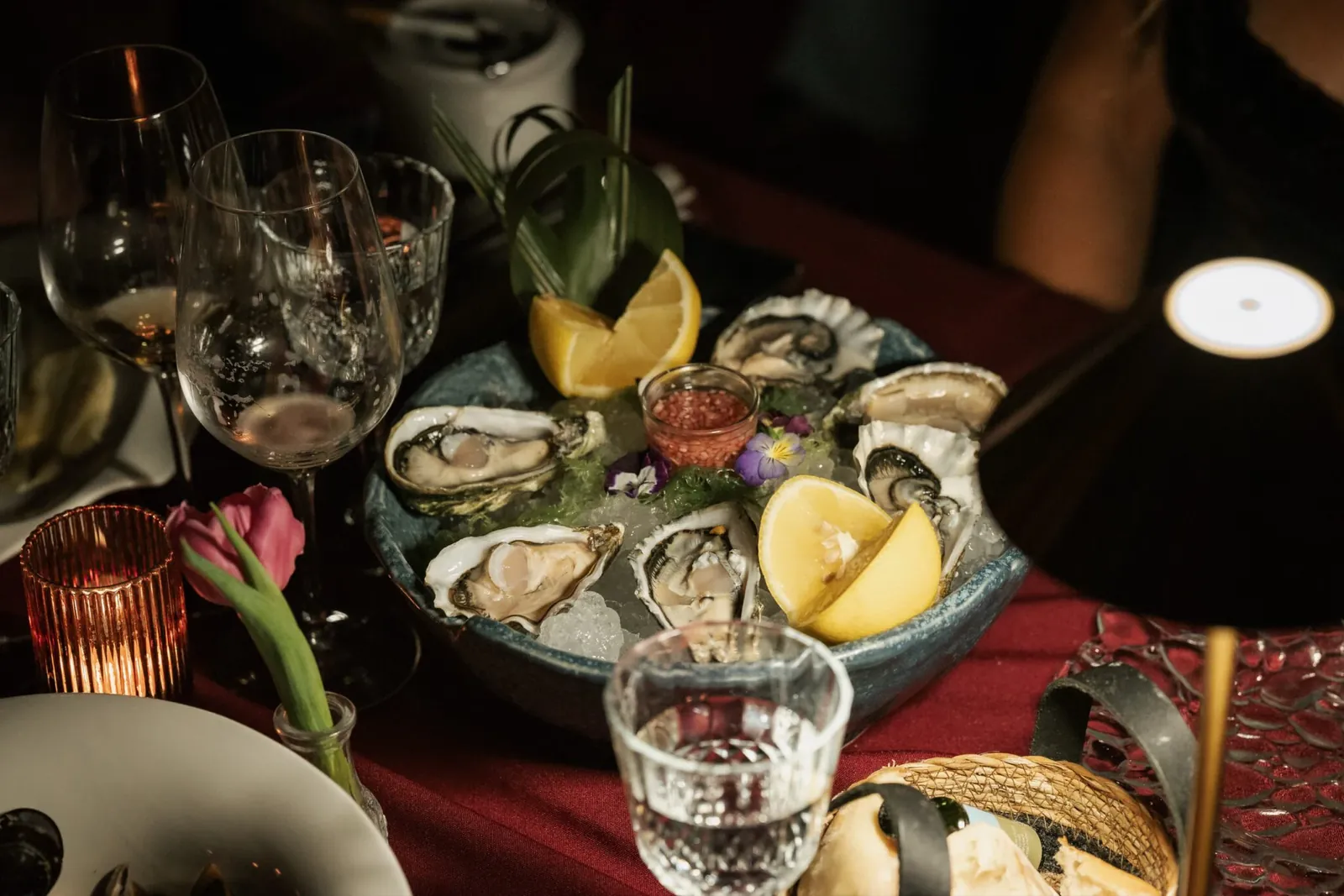 Huîtres et quartiers de citron dressés sur une nappe rouge à LØV Marbella