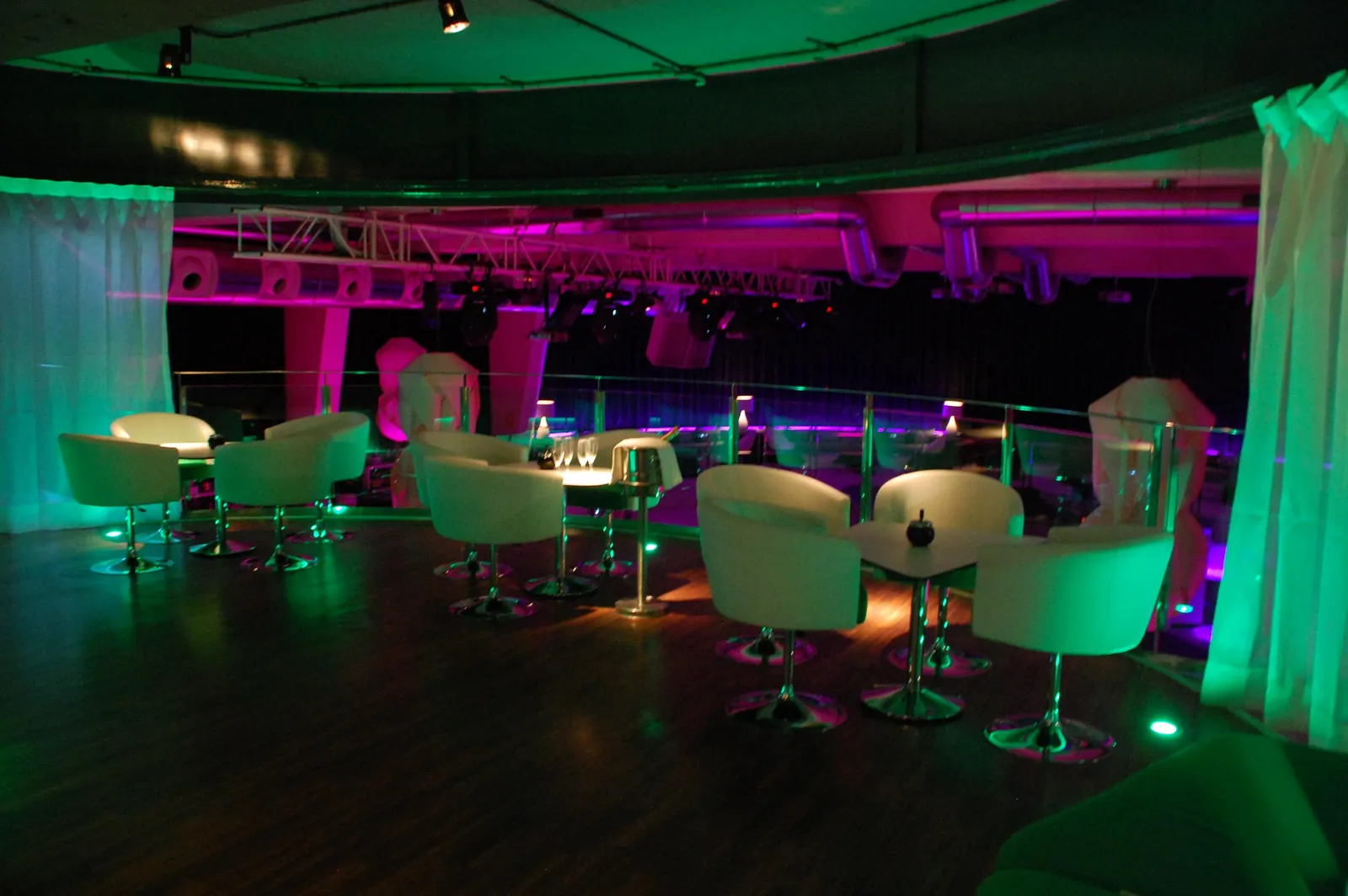 Lounge area at Mya Valencia with white armchairs and round tables