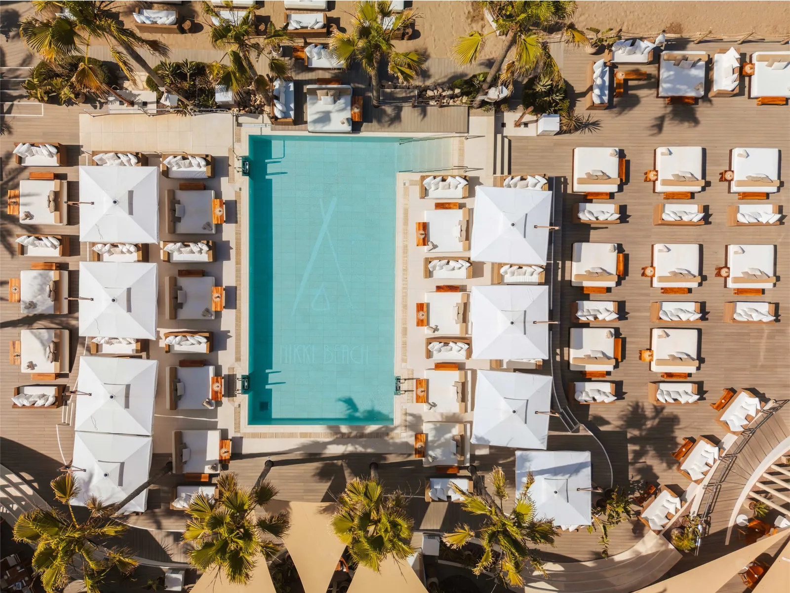 Aerial view of Nikki Beach Marbella pool surrounded by white sun loungers
