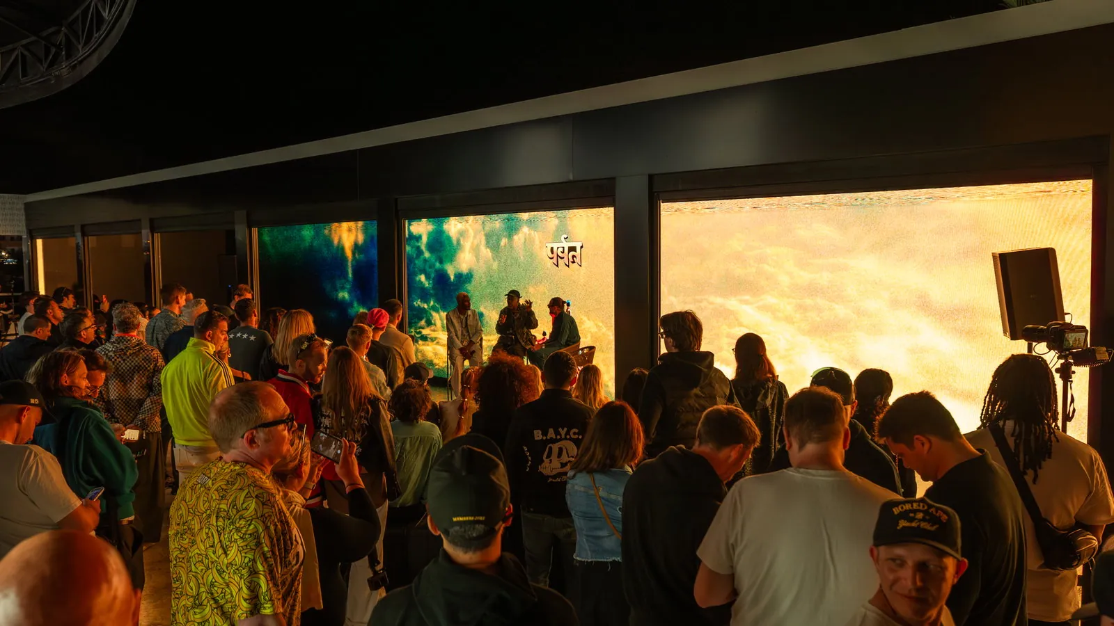 Public de l'Ushuaïa Ibiza dans un espace lounge avec écrans projetés