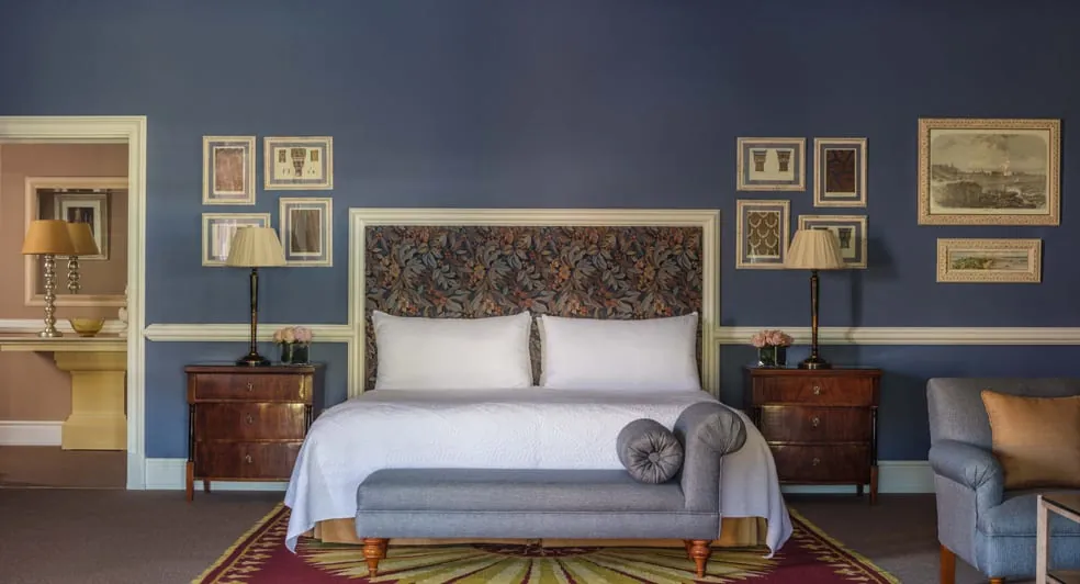 Anantara Villa Padierna suite in Benahavís with floral headboard and deep blue walls