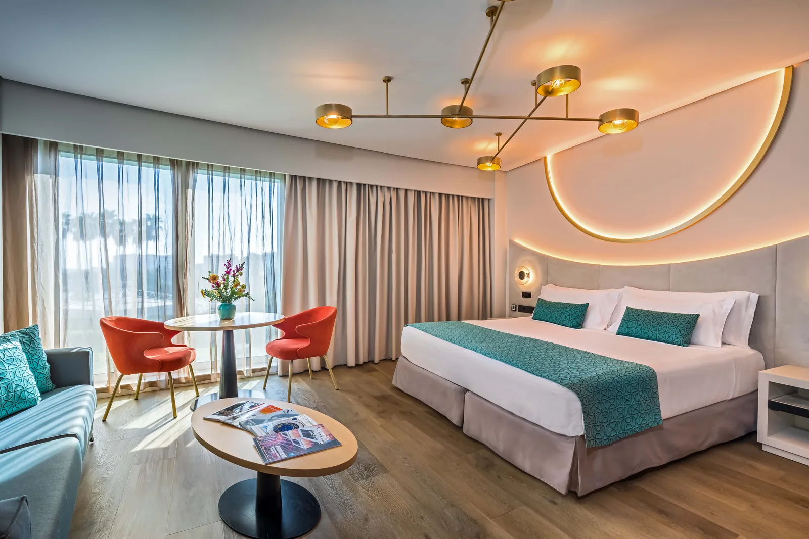 Deluxe room with red armchairs and large window at Barceló Sevilla Renacimiento