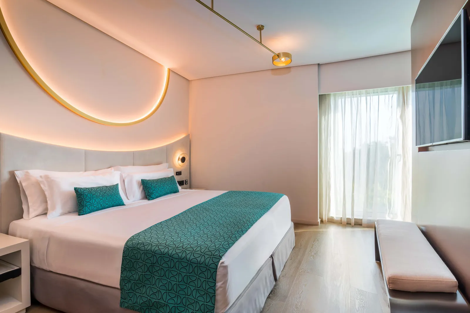 Modern room with arched ceiling lights and turquoise accents at Barceló Sevilla Renacimiento