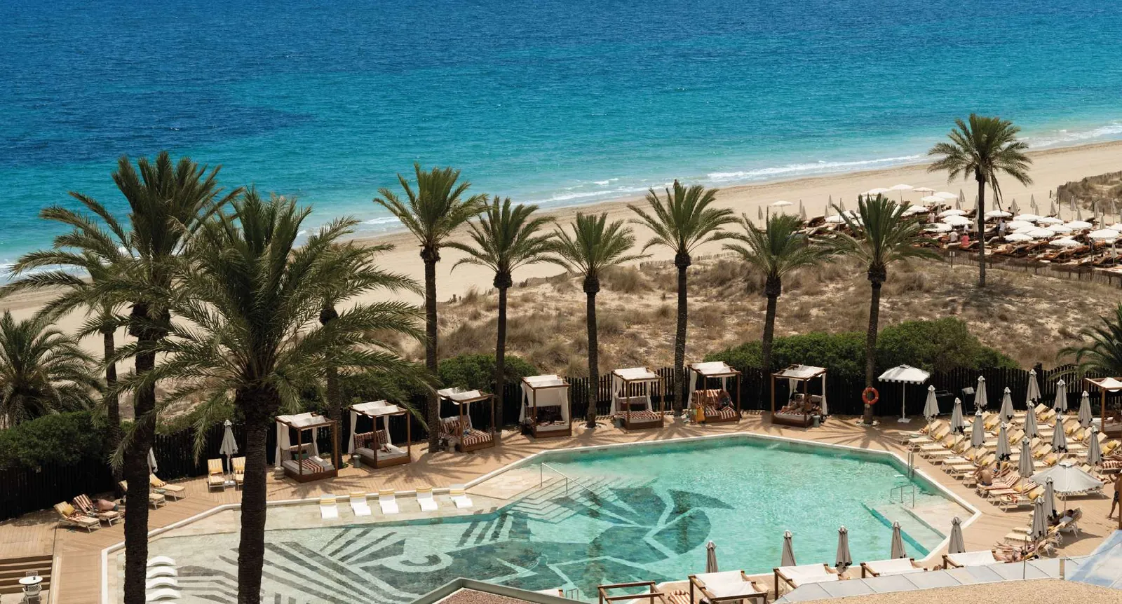 Pool und weißer Sandstrand von BLESS Ibiza The Site in Playa d'en Bossa