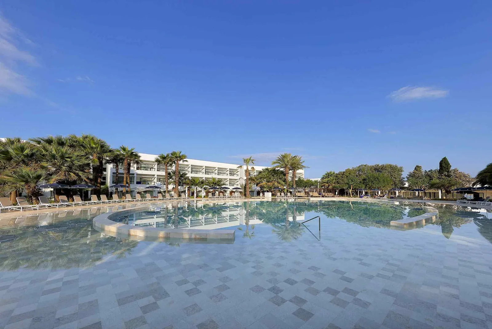 Oval pool at Grand Palladium Palace Ibiza surrounded by white buildings