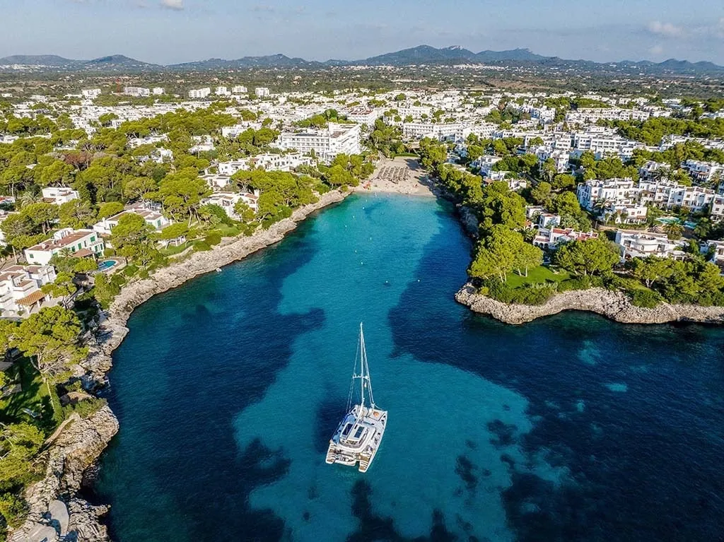 Aerial view of the Cala Gran cove and its white hotels in Cala d'Or