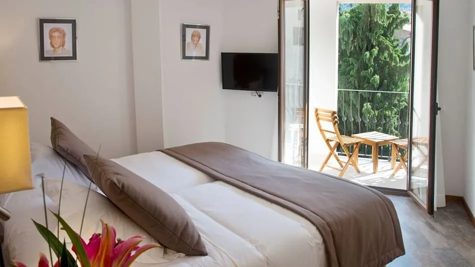 Double bedroom at Gran Hotel Sóller with balcony overlooking greenery in Sóller