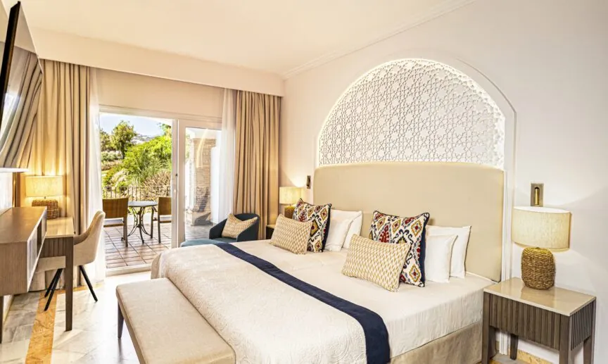 Guest room at La Cala Resort with lattice headboard and terrace in Mijas