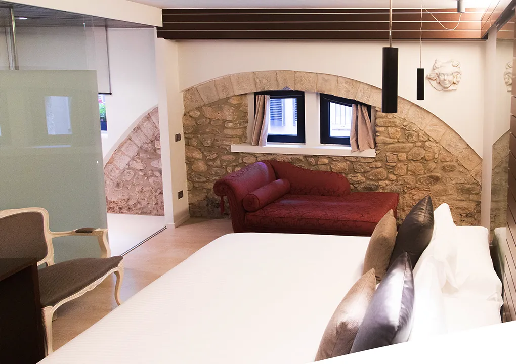 Double room at Hotel Llegendes de Girona with exposed stone wall
