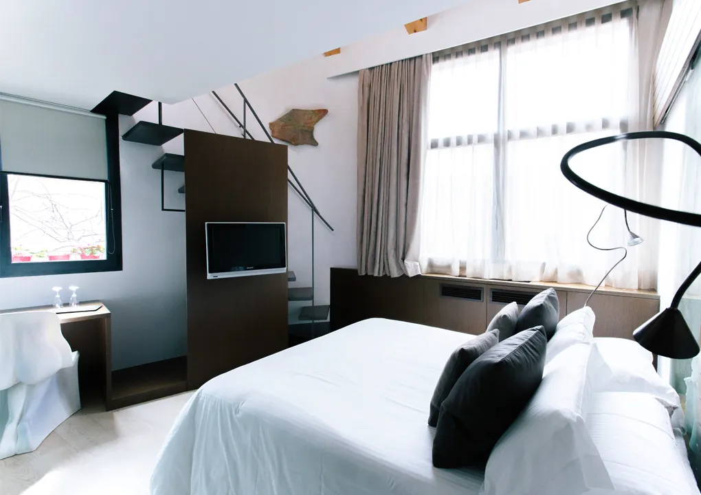 Junior duplex room at Hotel Llegendes de Girona with bed and bathroom