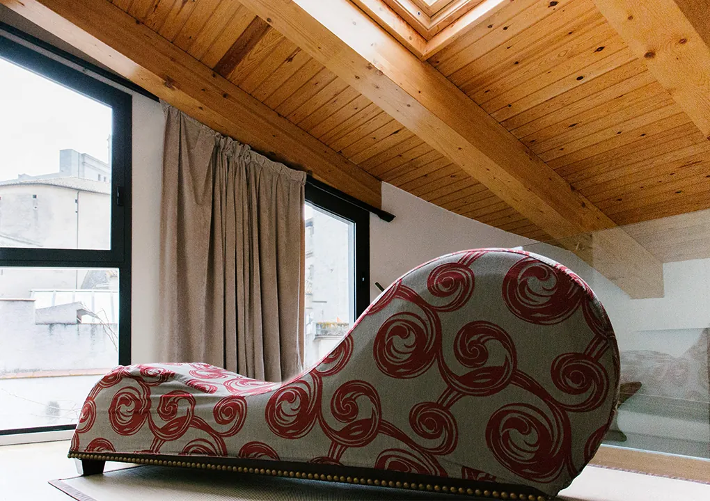 Eros suite at Hotel Llegendes de Girona with chaise longue and wooden ceiling