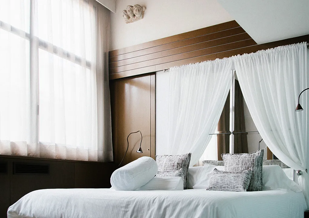 Margarita suite at Hotel Llegendes de Girona with bed and white curtains