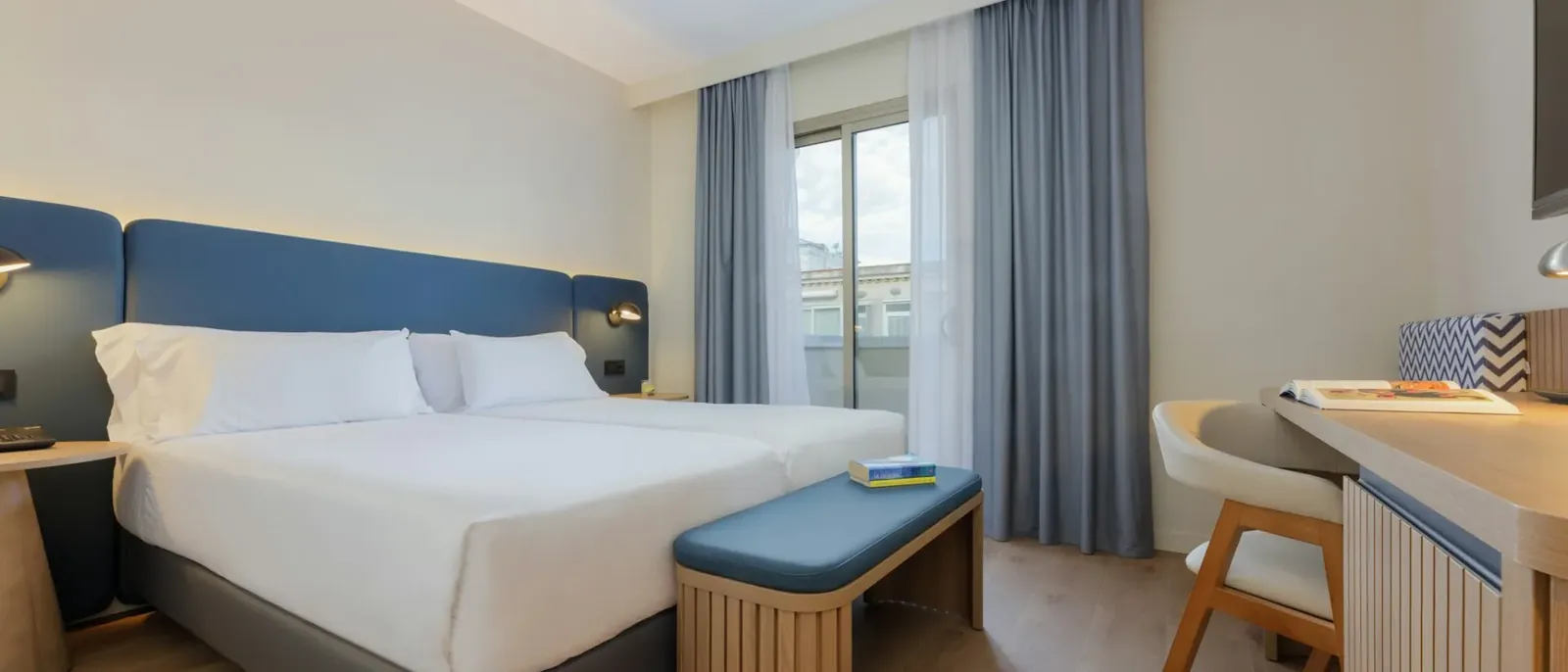 Twin room with blue headboard at Kalma Sitges hotel