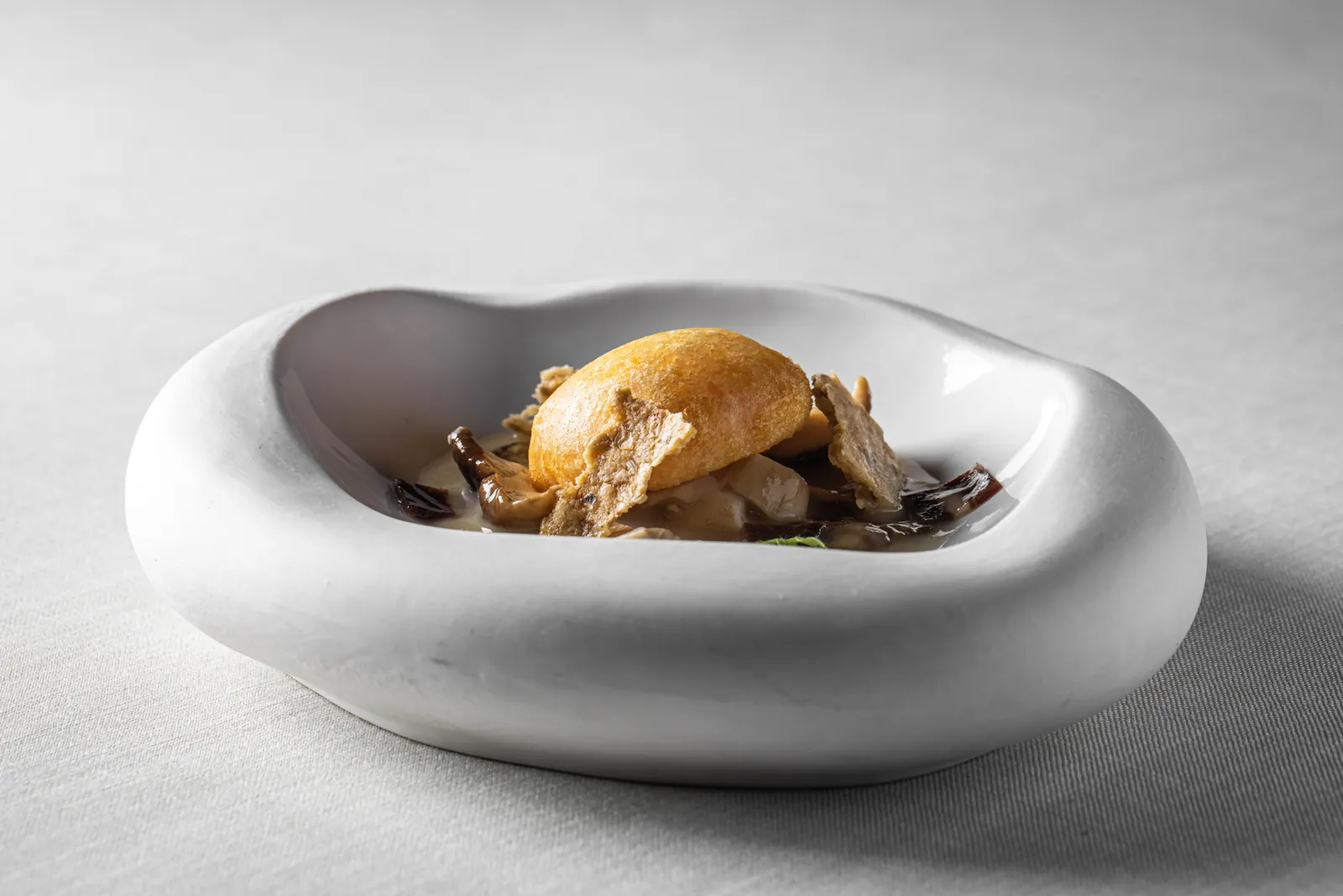 Gourmet dish in a white bowl at Abantal in Seville