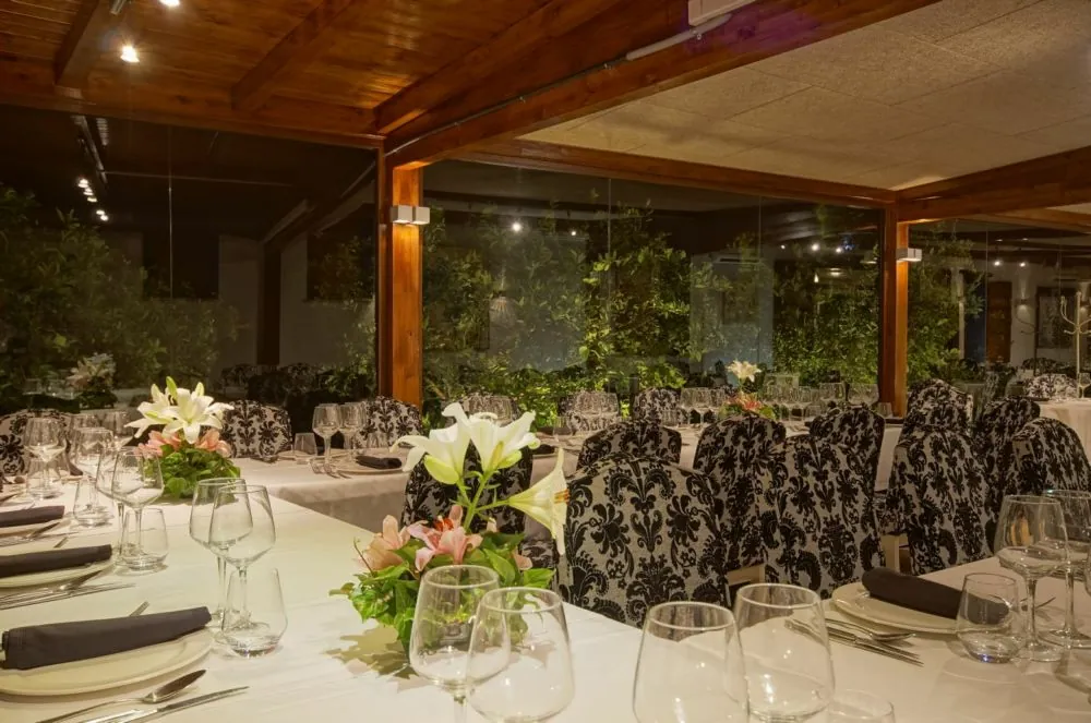 Banquet room with flower-decorated tables and glasses at Alquería del Brosquil