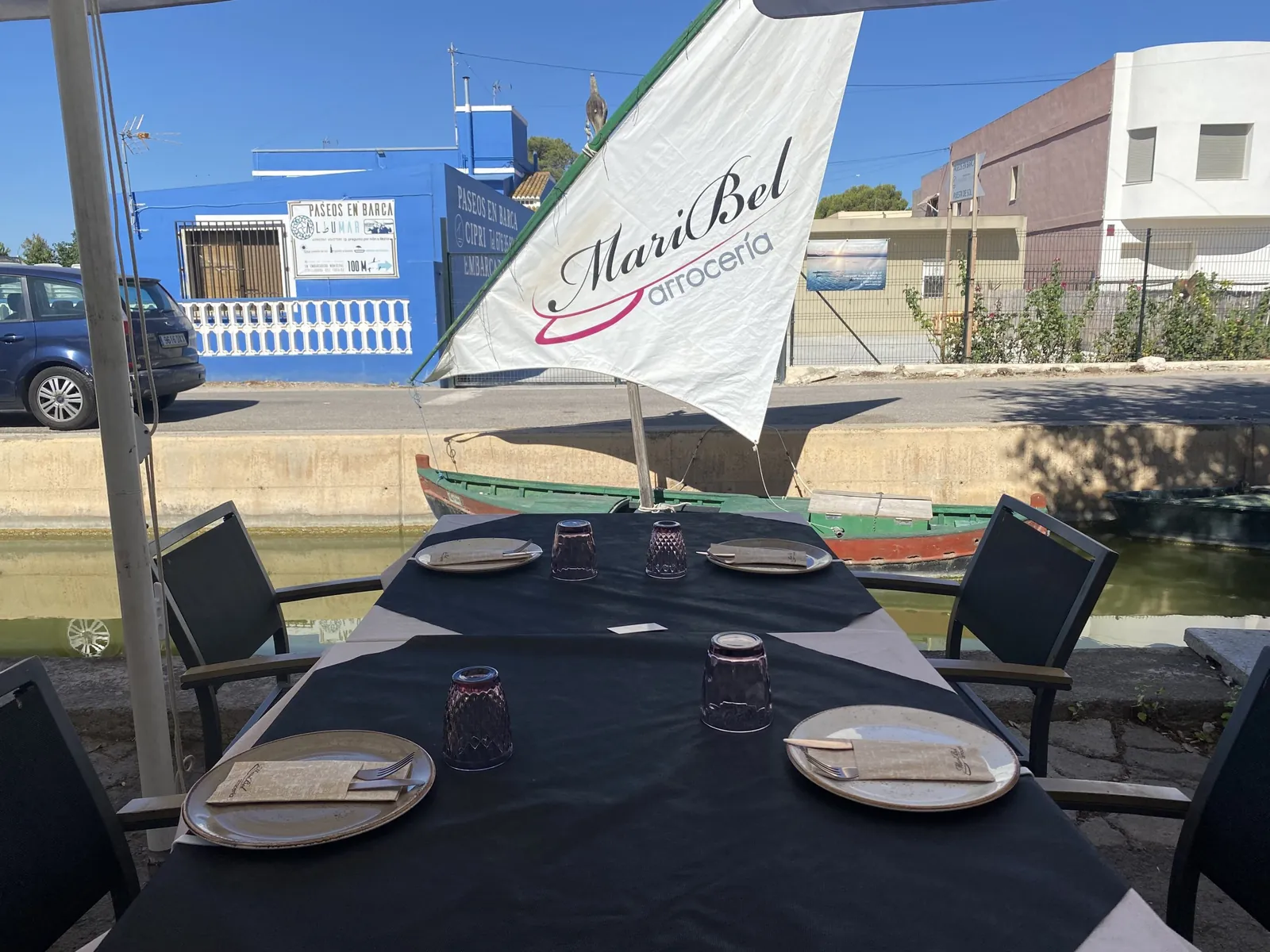 Set table on the terrace with the Maribel sail logo by the canal