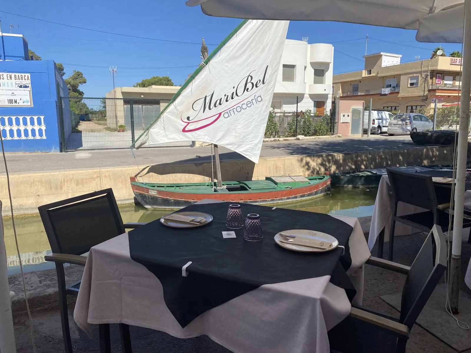 Arrocería Maribel terrace with black tablecloths and sail sign