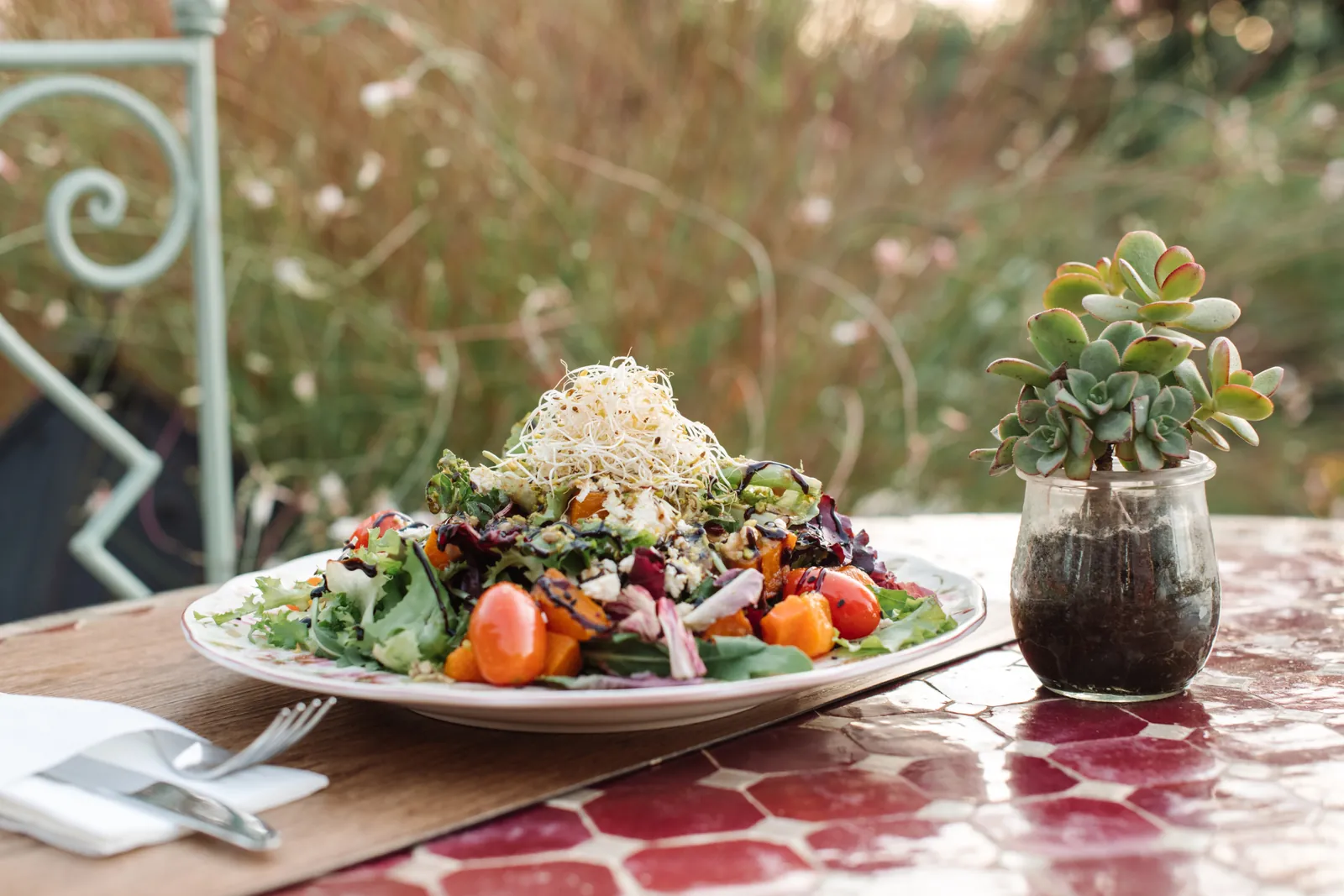 Fresh salad served on a floral plate at Aubergine by Atzaró in Ibiza