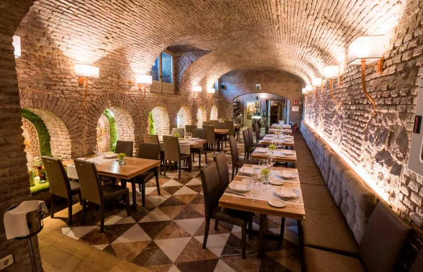 Vaulted brick dining room of Café de Oriente in Madrid with set tables