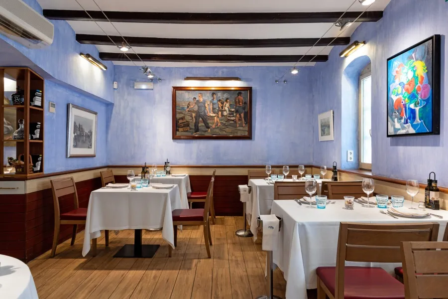 Can Majó restaurant room with blue walls and set tables in Barcelona