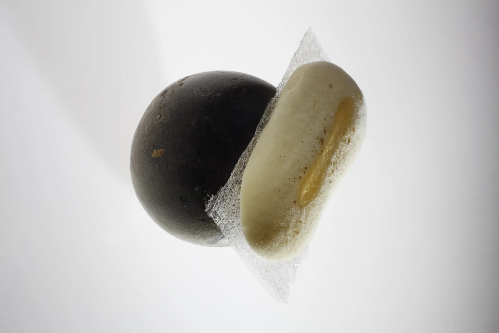 Creation at Disfrutar restaurant in Barcelona, black ball and pale oval on white background