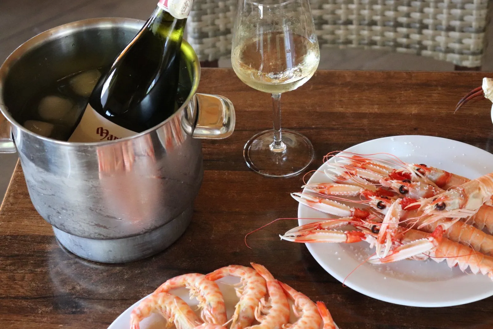 Crevettes et vin blanc servis à table chez Doña Gamba à El Rompido