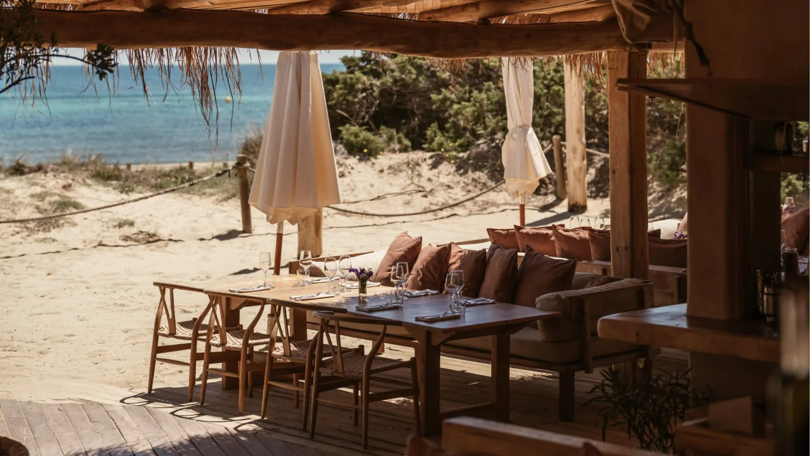 El Chiringuito beach terrace in Ibiza with wooden tables facing the sand