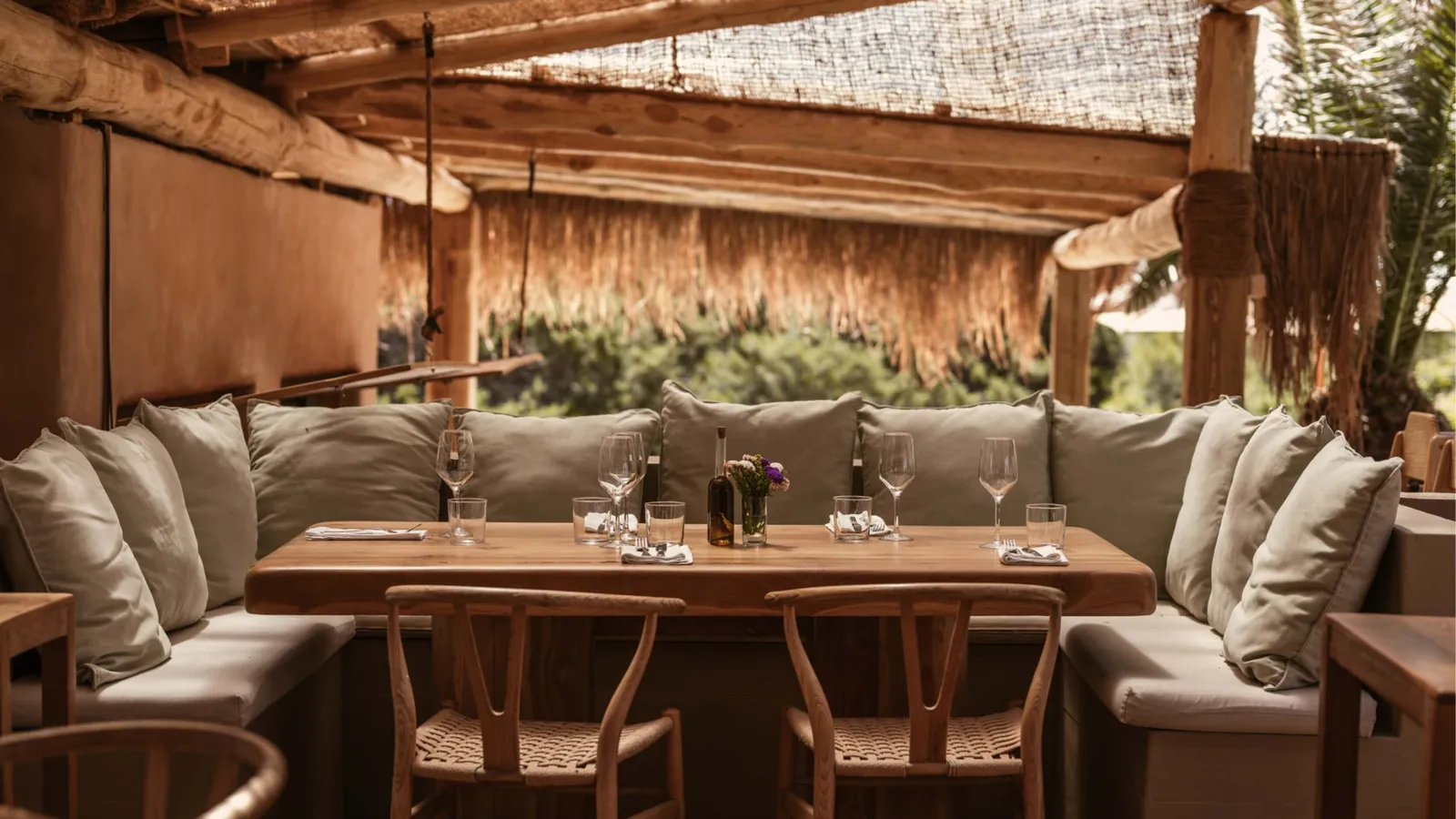 Outdoor lounge seating at El Chiringuito in Ibiza under a thatched roof