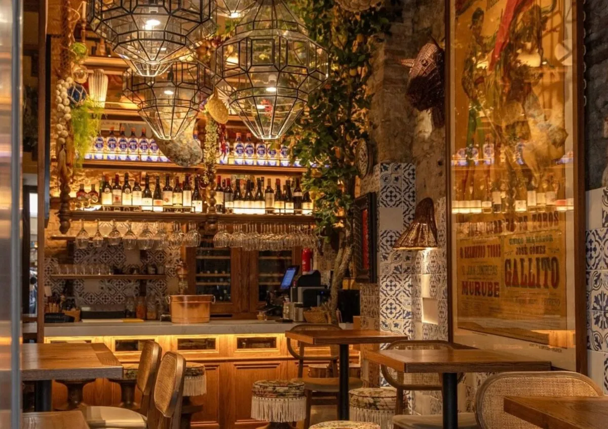 Lively bar interior at El Pimpi in Málaga with chandelier and green plants