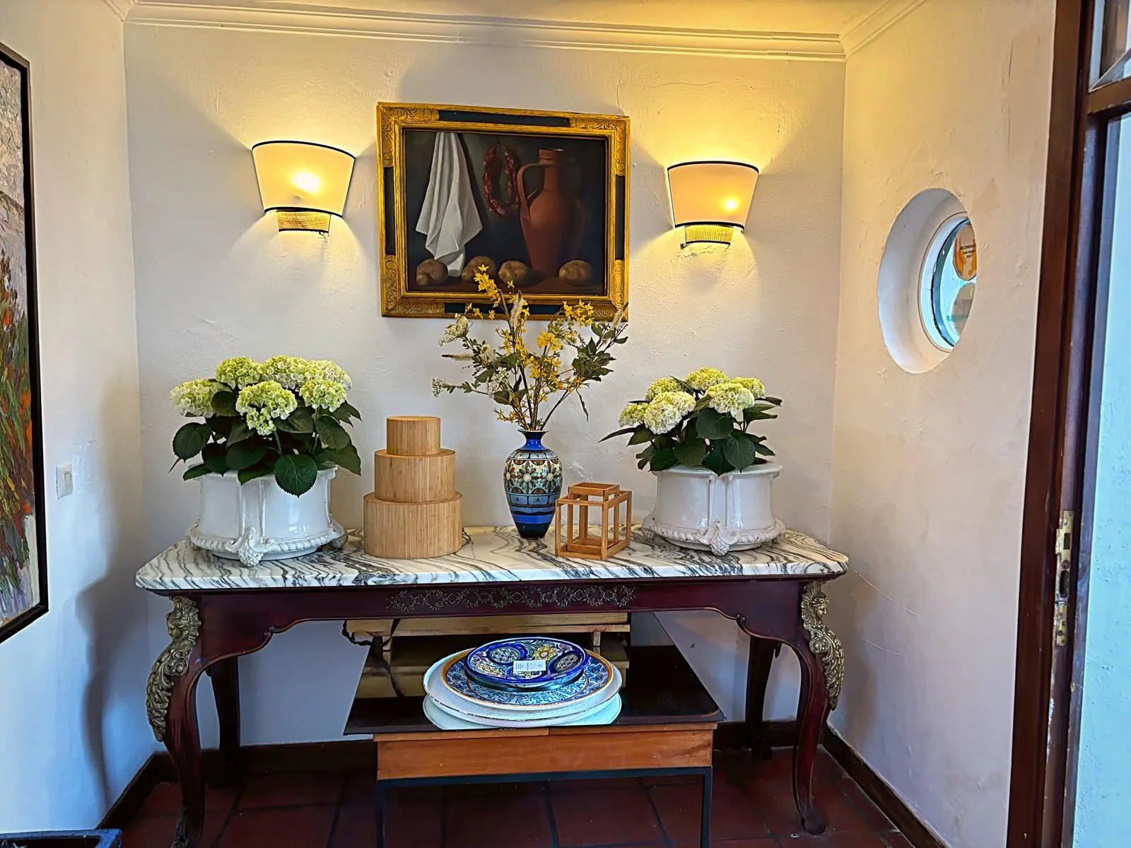 Salon at La Tirana in Marbella with framed painting, wall lights and white flowers