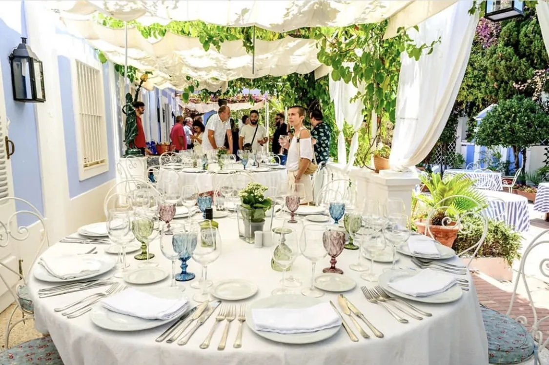 Table set under a white pergola at La Tirana in Marbella